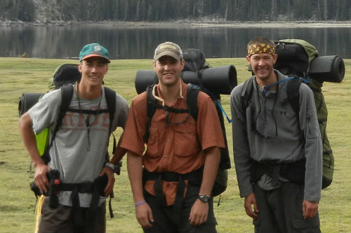 3 MBA Students with Backpacks Standing in front of a Lake
