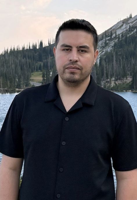 photo of mohammad hasaninia wearing a black suit jacket over a cream colored shirt against a white background