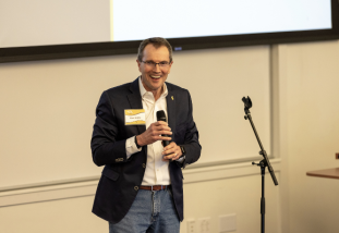 faculty member talks in front of a crowd