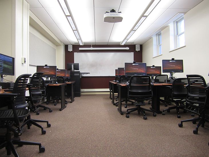 rows of computers with projector at the very back