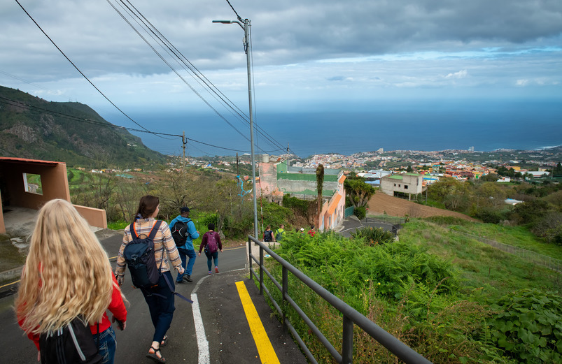 Students walk down a road toward a rural town in the Canary Islands