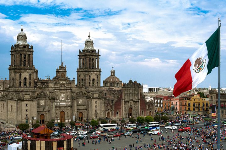 view of large, ornate building and Mexican flag