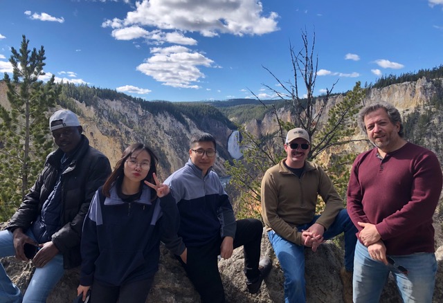 Lab staff posing in front of mountains on a sunny day.