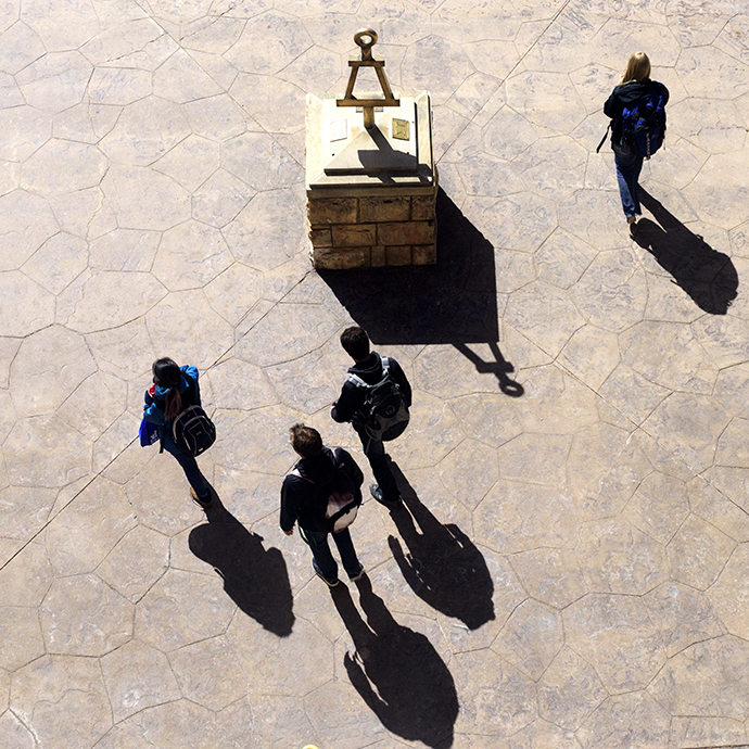 MPA students walking past a statue of a protractor