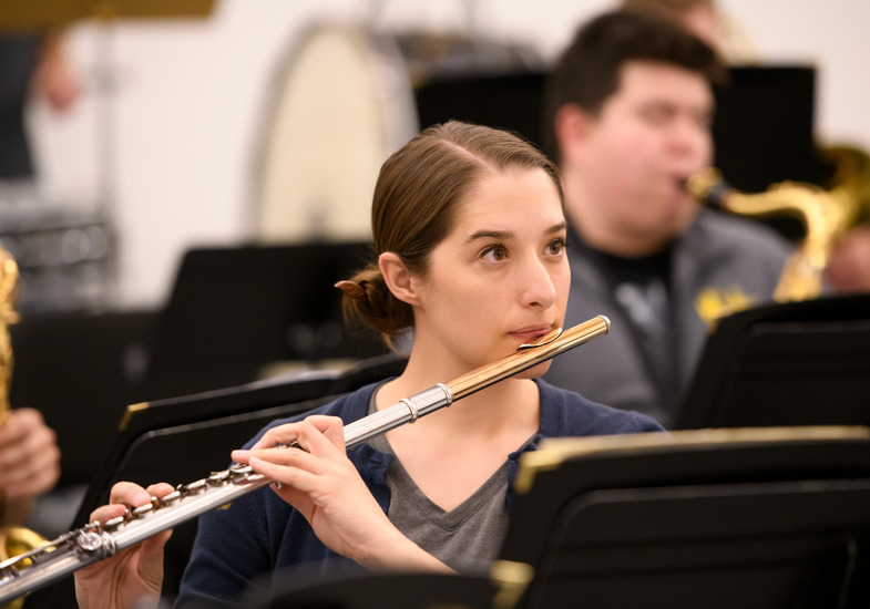 A flutist playing in an ensemble.