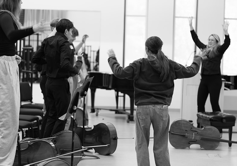 Students in a circle with hands in air