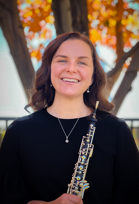 Picture of woman smiling while holding an oboe