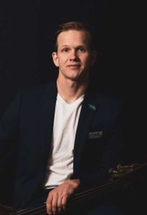 Photo of Seth Lewis holding a double bass