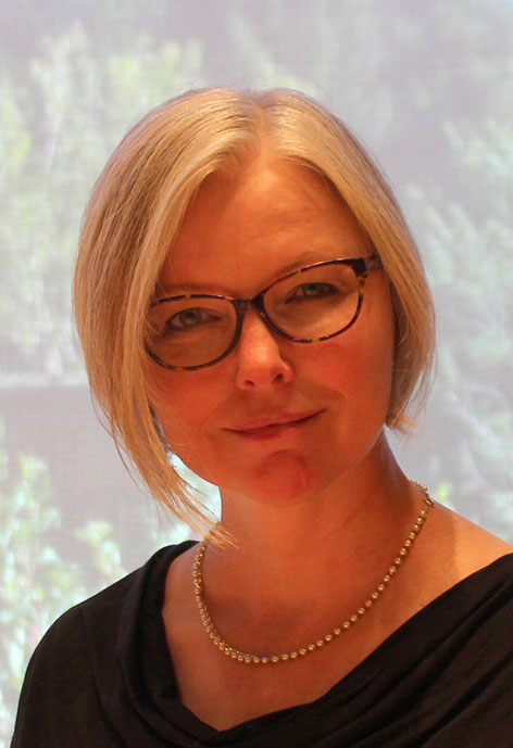 Photo of Dr. Crystal Sieger in a black top with a pearl necklace and tortoiseshell glasses