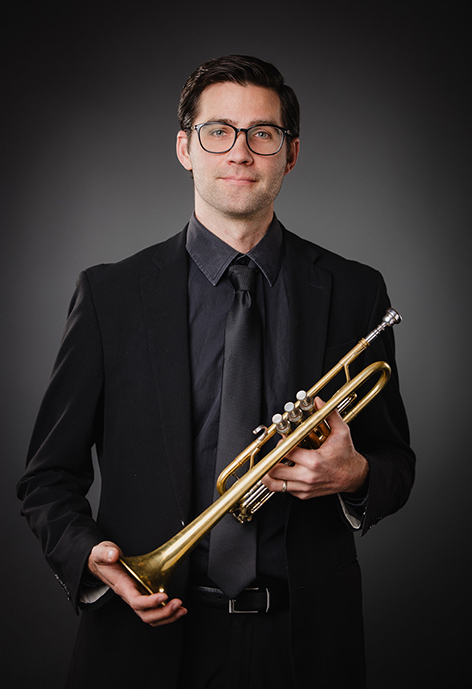 Photo of Dr. David Wharton in an all-black suit holding a trumpet