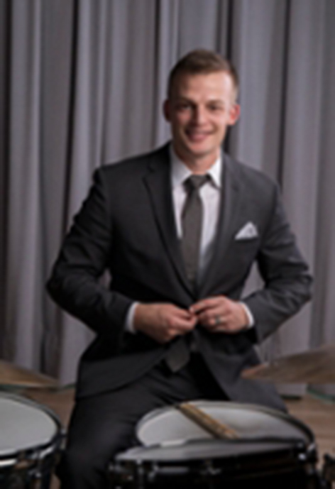Photo of Dr. Andrew Wheelock sitting in front of a drumset