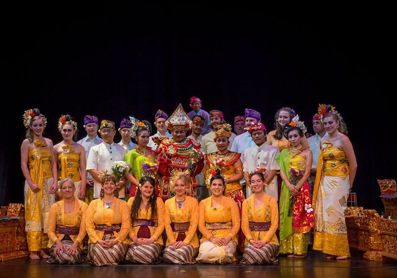 Members of Gamelan Candra Wyoga pose after a concert, dressed in traditional Balinese outfits in front of the instruments.