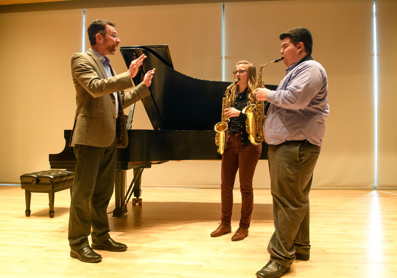 Saxophone professor coaching two students on a piece