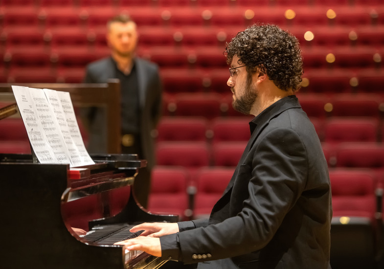 Student playing piano on stage