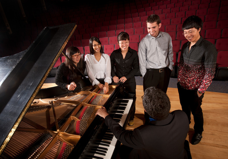 Piano students learning from instructor in class