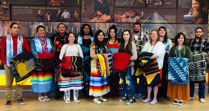 a group of graduates with native blankets