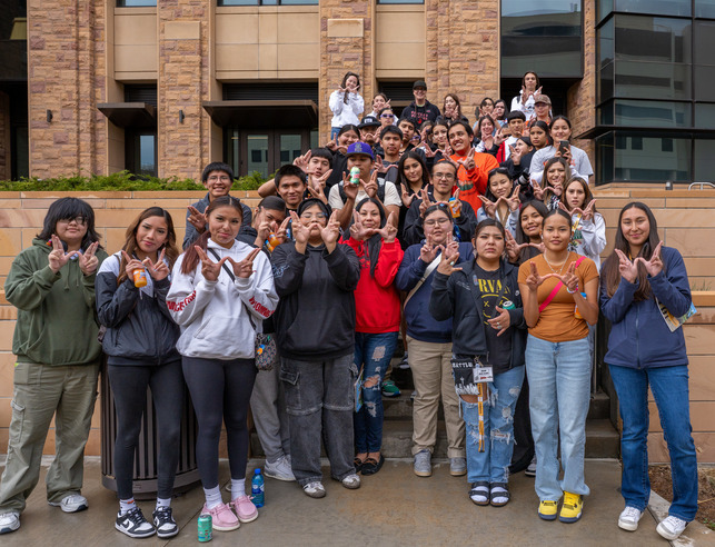 Group of students making a W with their hands on campus at the Native American Summer Institute