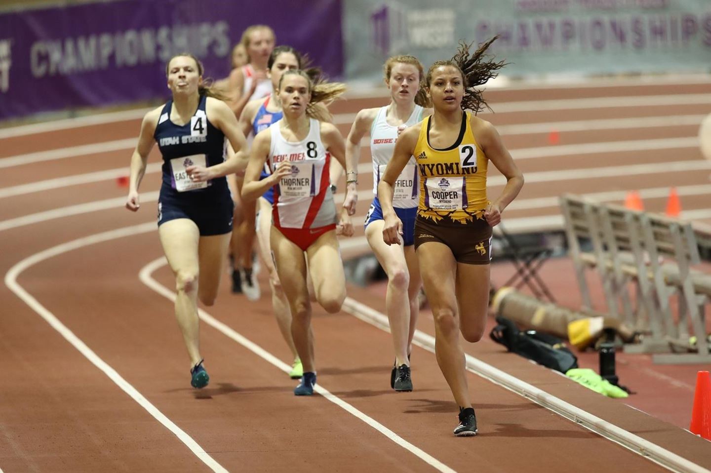 girls on track team run through a race