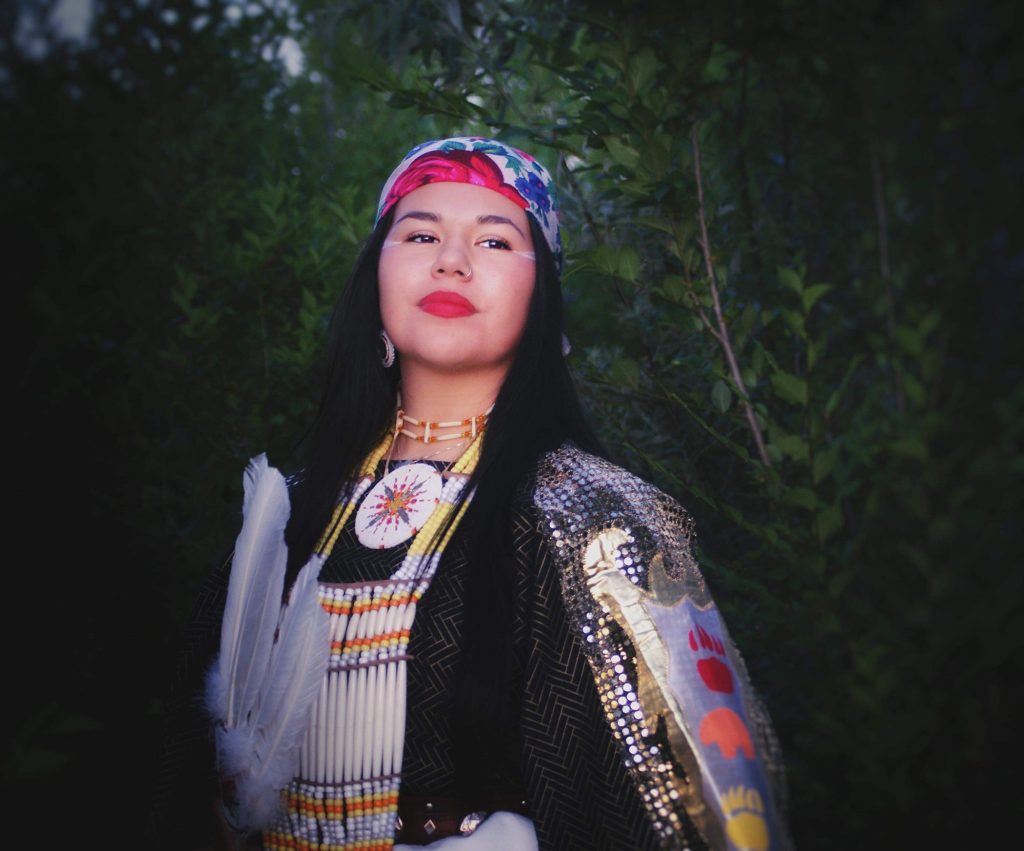 woman graduate hold native american traditional regalia