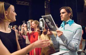 Play actors holding up photos of selves