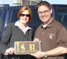Man and woman holding license plate