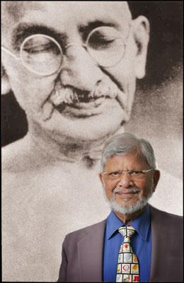 Arun Gandhi stands before image of Mahatma Gandhi
