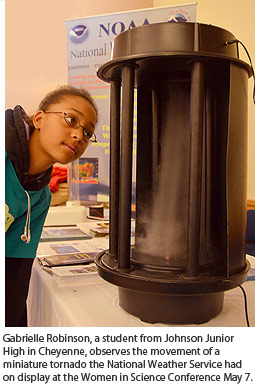 Gabrielle Robinson, a student from Johnson Junior High in Cheyenne, observes the movement of a miniature tornado.