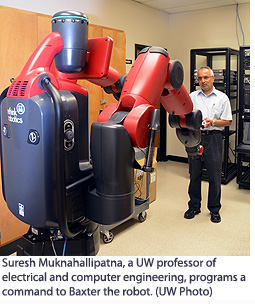 Suresh Muknahallipatna, a UW professor of electrical and computer engineering, programs a command to Baxter the robot. 