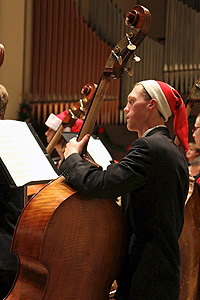 Man in santa hat playing upright bass