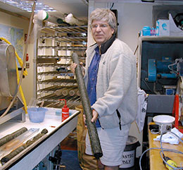 man in room full of equipment holding a core sample
