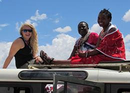 three women sitting on top of a vehicle