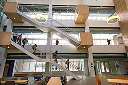 students using stairs in atrium of large building