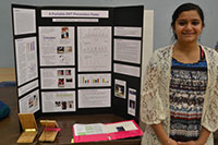 young girl standing beside science fair tri-fold display