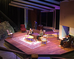 people on a stage set made to look like a living room