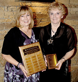 two women holding plaques