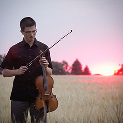man holding a viola in a field