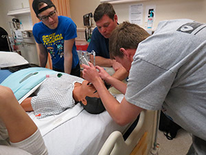 person practicing a procedure on a medical mannequin