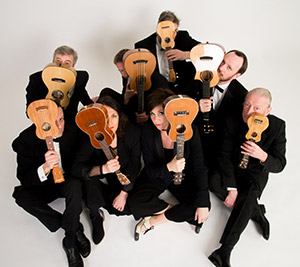 group in formal clothing holding ukeleles