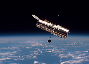 The Hubble Space Telescope moves slowly away from the space shuttle Discovery.