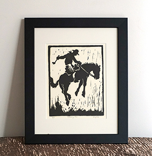 framed woodblock print of cowboy on bucking horse