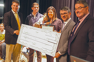 group of people holding an oversized check