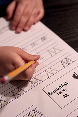 photo of child's hand tracing a W on a piece of paper