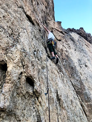 person climbing a rock face