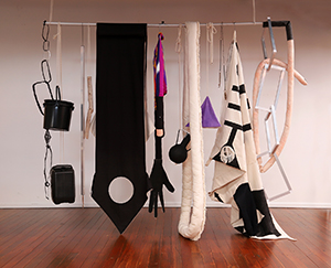 art from exhibit item draped over a metal pipe suspended from the ceiling