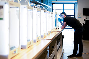 man with a row of 3D printers