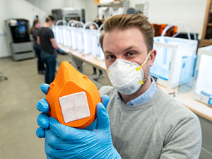 man holding up a 3D printed mask