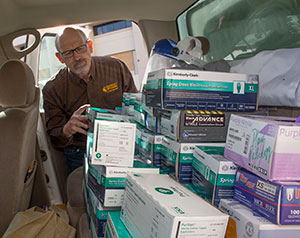 person loading car with medical supplies