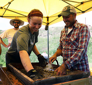 woman and man sift dirt