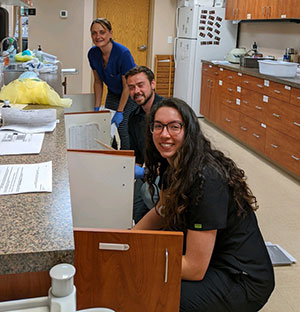 three people looking in cabinets