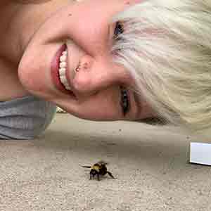 woman looking at bumblebee on the ground